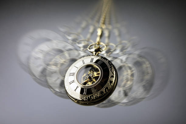 Hypnotism concept, gold pocket watch swinging used in hypnosis treatment